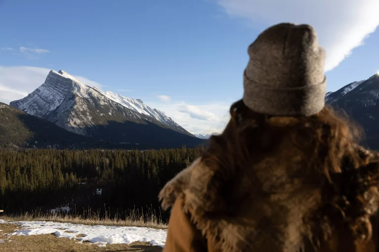 Guest looking out at winter view of Rundle mountain from Juniper hotel